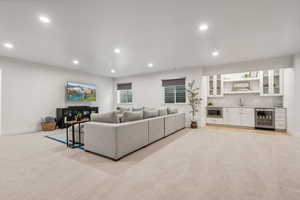 Carpeted living room featuring a kitchenette