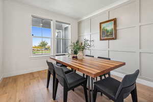 Formal dining room or second office featuring crown molding and light hardwood / wood-style flooring