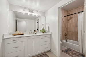 Full bathroom with tile patterned floors, shower / bath combo, vanity, and toilet