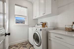 Laundry room featuring cabinets and washing machine and dryer