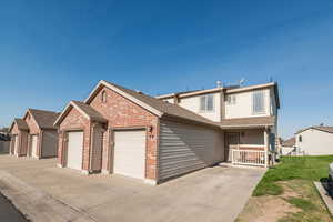 View of front facade featuring a garage and a front lawn