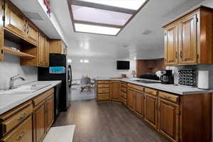 Kitchen with dark flooring, updated stove-top, ample cabinets.