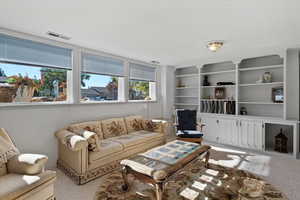 Lower level living room built-ins with cabinets and open shelving.