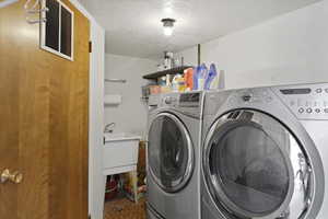 Laundry room with deep wash basin sink, shelving, and hanging rack.