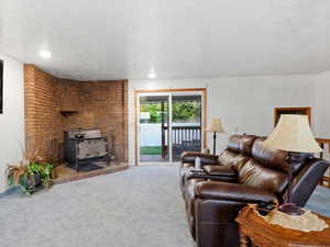 View of main floor family room with a wood stove. Exterior sliding glass door to new cedar porch.