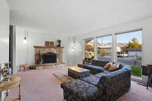 Main level living roomwith floor to ceiling window and a woodburning fireplace with stone hearth.