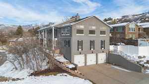 View of snow covered exterior with a mountain view and a garage