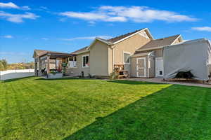 Back of house featuring a pergola and a yard