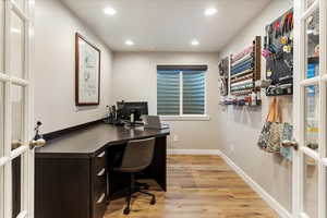 Home office with french doors and light wood-type flooring