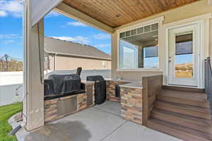 View of patio / terrace featuring an outdoor kitchen, sink, and grilling area