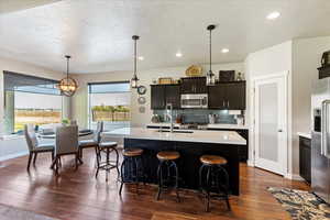 Kitchen featuring an island with sink, plenty of natural light, and stainless steel appliances