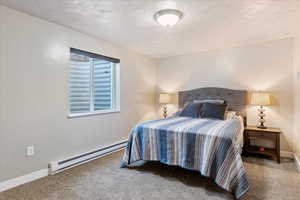 Carpeted bedroom with a baseboard radiator