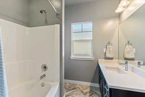 Bathroom featuring shower / bath combination, parquet floors, and vanity