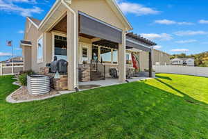 Rear view of house featuring a yard, a pergola, and a patio