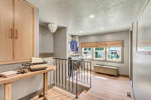 Interior space featuring light hardwood / wood-style floors and a textured ceiling