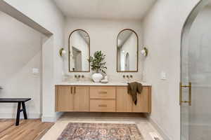 Bathroom featuring walk in shower, vanity, and hardwood / wood-style floors