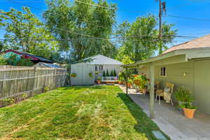 View of yard featuring a storage unit, a patio, and outdoor lounge area