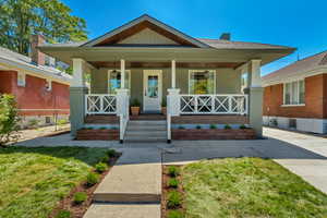 Bungalow-style house with a front lawn and covered porch