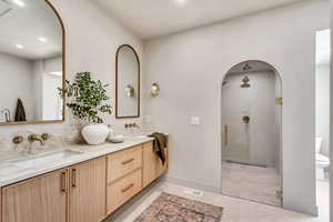 Bathroom with tile patterned flooring, a shower with door, vanity, and toilet