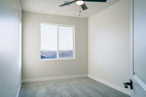 Carpeted spare room featuring ceiling fan