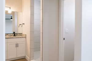 Bathroom featuring vanity, a shower, and hardwood / wood-style floors