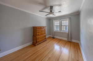 Unfurnished bedroom with ornamental molding, ceiling fan, and light hardwood / wood-style flooring