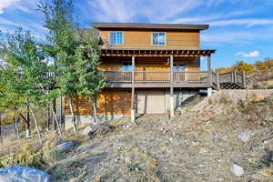 Rear view of house with a deck and a garage