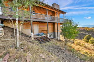 Rear view of property with a deck with mountain view