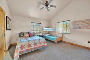 Bedroom with high vaulted ceiling, ceiling fan, and carpet floors