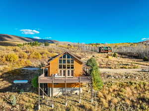 Rear view of property featuring a deck with mountain view