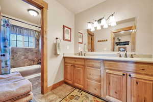 Bathroom with vanity, tile patterned floors, and shower / tub combo with curtain