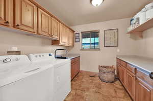 Laundry area featuring washing machine and clothes dryer and cabinets