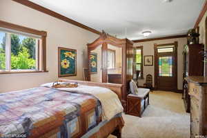 Bedroom with light carpet and crown molding