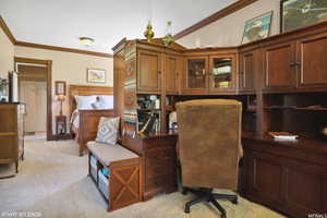 Home office with crown molding, vaulted ceiling, and light colored carpet