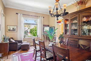 Dining space featuring ornamental molding, hardwood / wood-style floors, and a chandelier