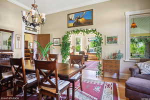 Dining space featuring ornamental molding, hardwood / wood-style flooring, and a chandelier