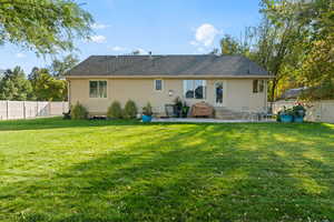 Back of property with a lawn and a patio area