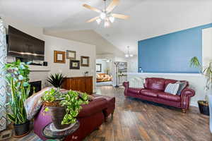 Living room with lofted ceiling, ceiling fan, and hardwood / wood-style floors