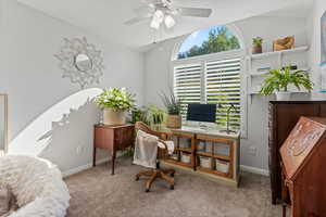 Carpeted office with ceiling fan and vaulted ceiling