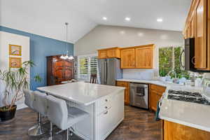 Kitchen with pendant lighting, a kitchen island, dark hardwood / wood-style flooring, sink, and appliances with stainless steel finishes