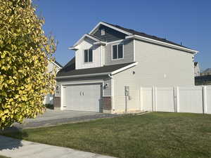 View of side of home featuring the garage and the south side gate.