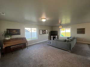 Living room with ceiling fan and carpet flooring