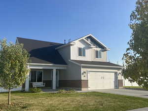 View of front facade featuring a front lawn, a porch, and a garage