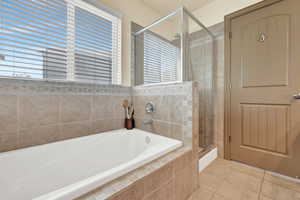 Spacious primary suite bathroom with separate tub and shower