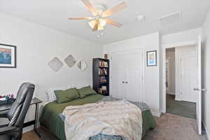 Bedroom featuring ceiling fan, carpet floors, and a closet