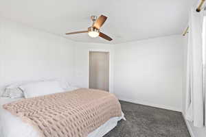 Master Bedroom with dark colored carpet and ceiling fan