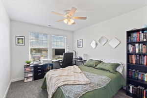 Carpeted bedroom featuring ceiling fan