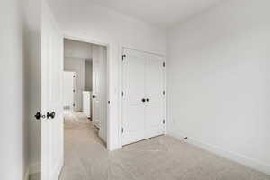 Unfurnished bedroom with baseboards, carpet floors, and a closet