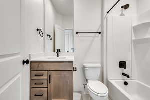 Full bath with toilet, bathing tub / shower combination, vanity, and baseboards