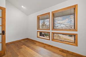 Spare room with vaulted ceiling and hardwood / wood-style flooring